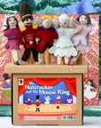 Felt dolls on a stage with 'The Nutcracker and the Mouse King' book in front, set against a snowy background.