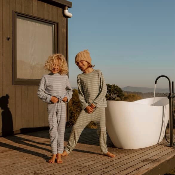 Temperature regulating Babu Merino Pyjama sets worn by two children in New Zealand on a cold morning. 