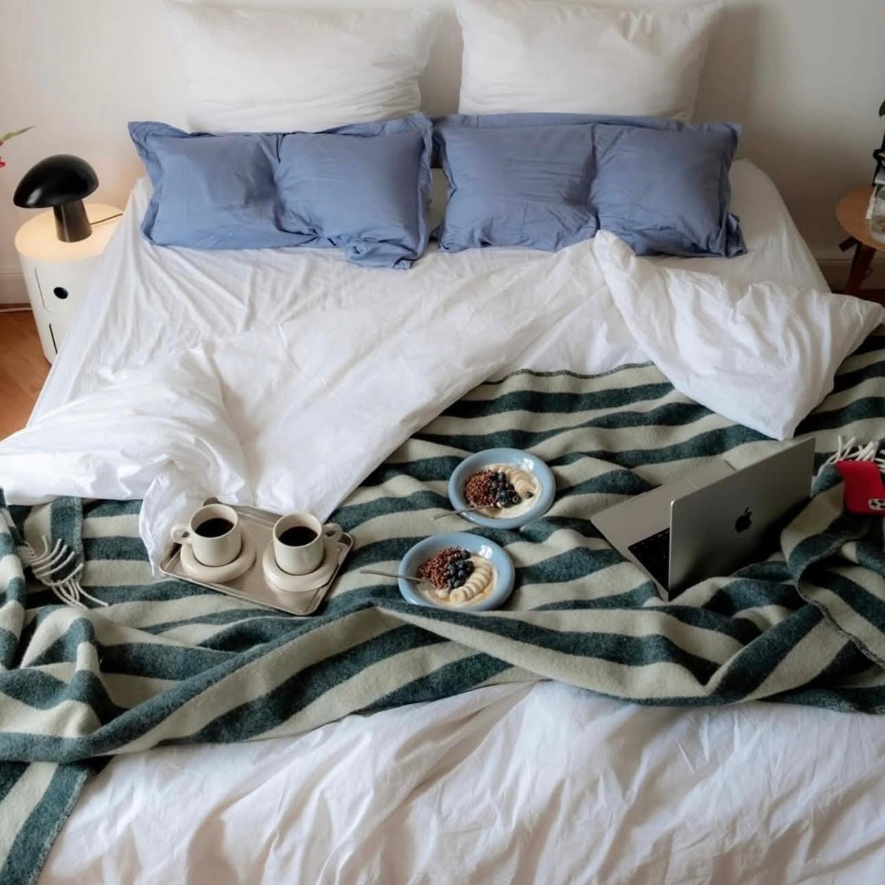 Striped Green Sage Wool Blanket Draped Over Bed For Cosy Relax and Work Space 