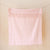 A light pink and white gingham checkered towel with fringed edges hanging from clips on a string against a light wood-paneled wall.