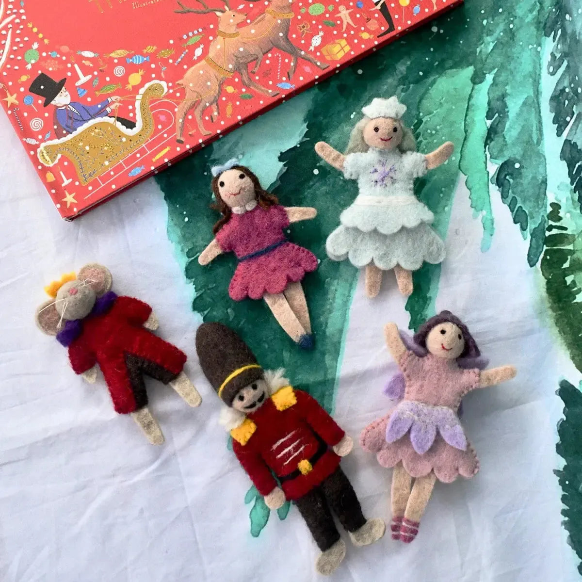 Set of small dolls with a colorful book in the background