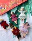 Set of small dolls with a colorful book in the background