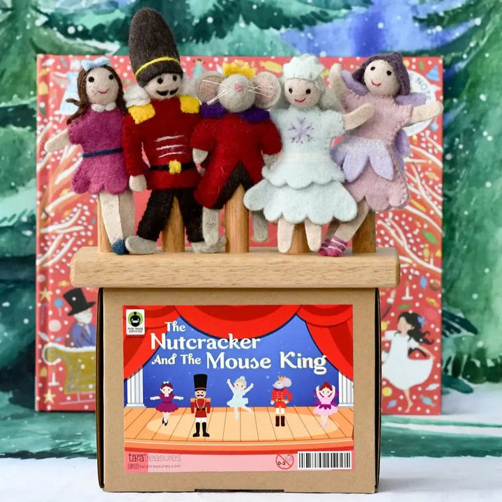 Felt dolls on a stage with 'The Nutcracker and the Mouse King' book in front, set against a snowy background.